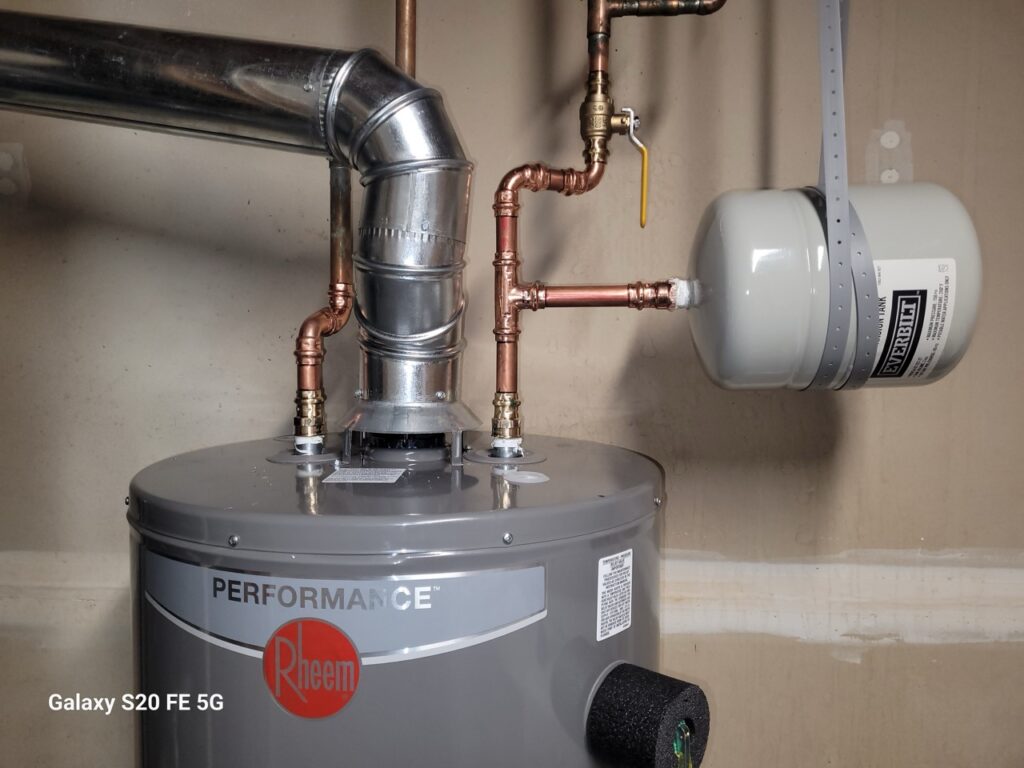 Home Basement plumbing setup with water heater, copper pipes, and HVAC connections by Perfectum Plumbing in Gaithersburg, MD.
