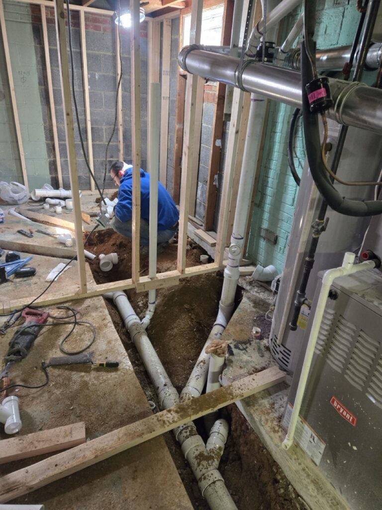 Home Plumber installing new PVC drain lines in a Gaithersburg basement renovation and sewer line replacement.