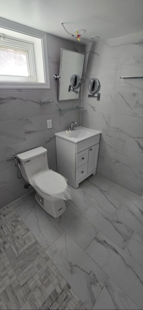 Gallery Newly remodeled bathroom with tile walls, vanity, and toilet by Perfectum Construction & Plumbing.
