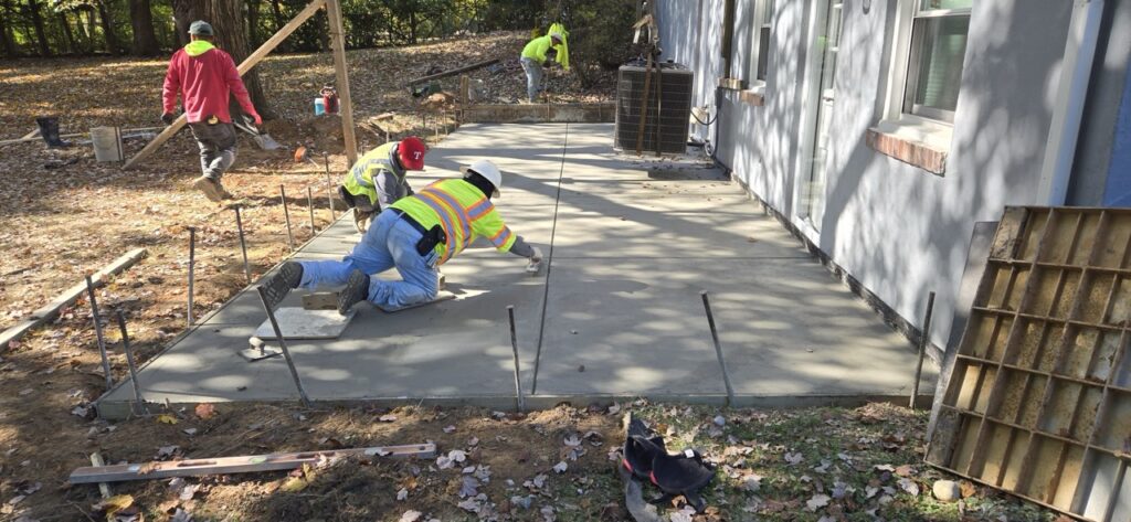 Gallery Perfectum Construction and Plumbing crew completing concrete patio and foundation work in Gaithersburg, MD.