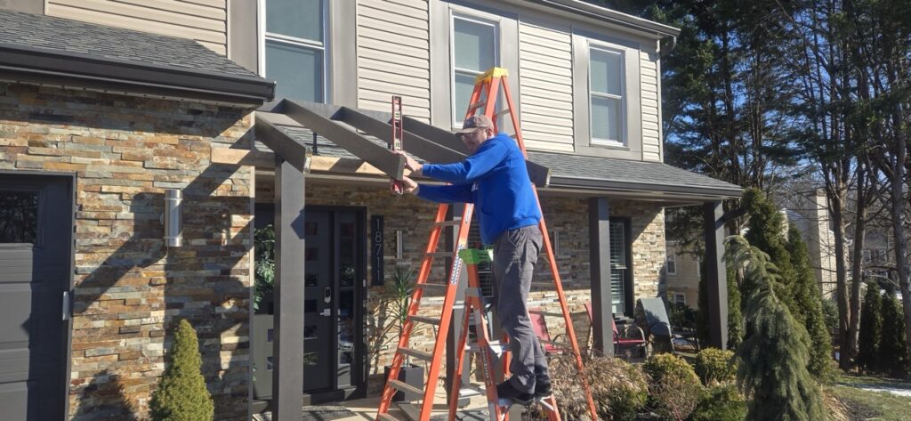 Gallery Perfectum Construction and Plumbing worker installing roofing and gutters on a Gaithersburg, MD home.