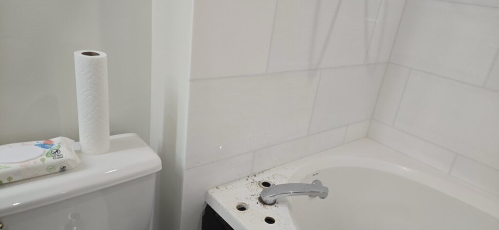 Gallery Bathroom remodeling project by Perfectum Construction & Plumbing: newly tiled walls and updated bathroom fixtures.
