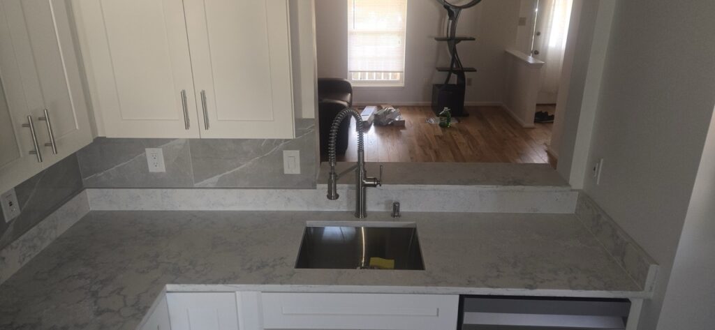 Gallery Newly remodeled kitchen with gray countertops and stainless steel sink by Perfectum Construction & Plumbing.