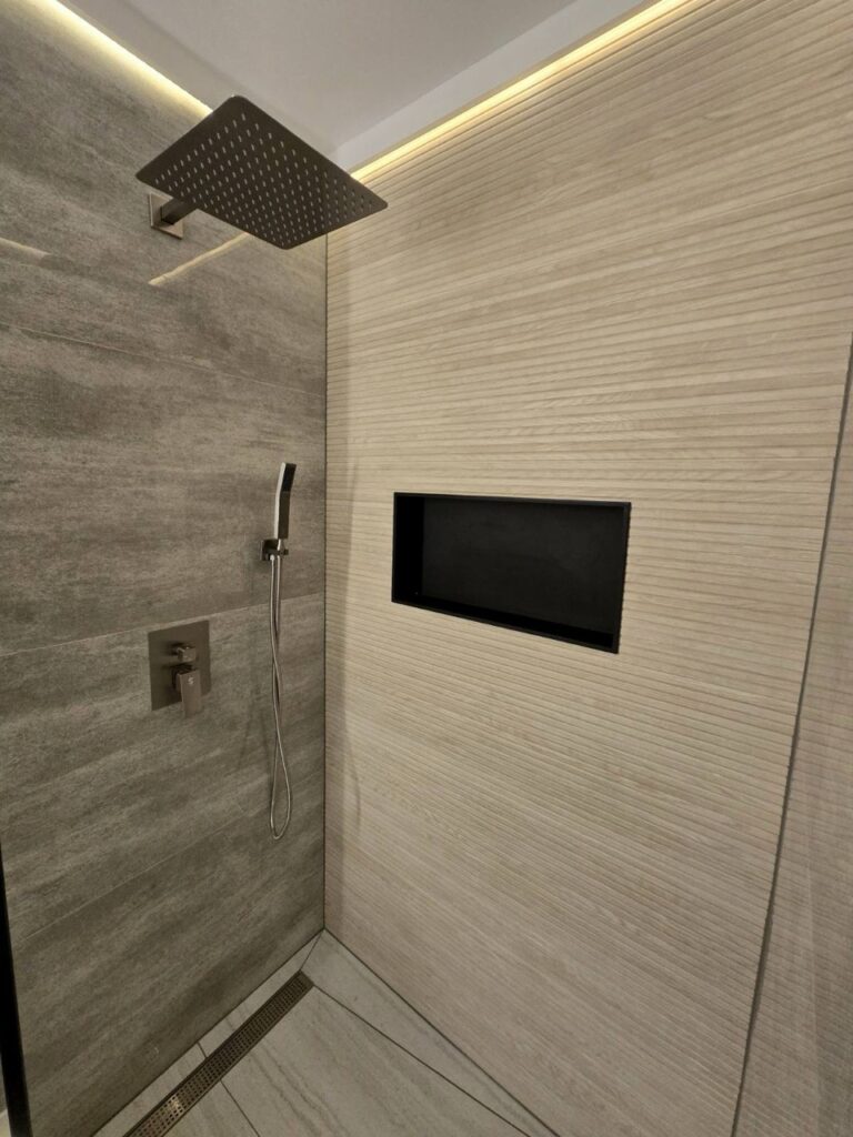 Gallery Modern bathroom shower remodel with tile and rainfall showerhead by Perfectum Construction & Plumbing.