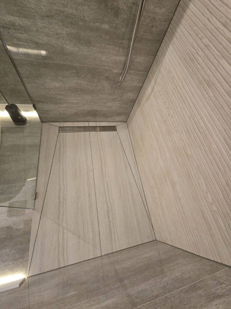 Gallery Newly remodeled bathroom shower with tile walls and floor by Perfectum Construction & Plumbing.