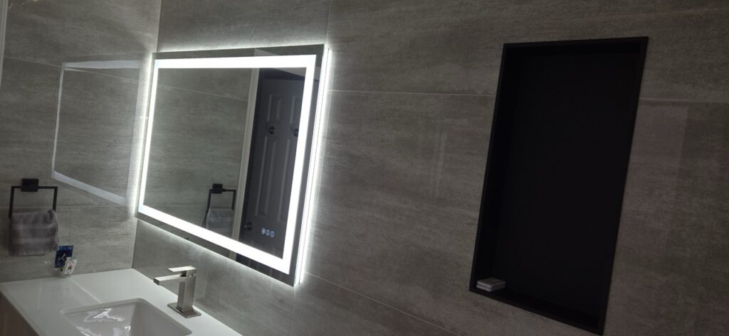 Gallery Modern bathroom remodel with illuminated mirror and stylish vanity by Perfectum Construction & Plumbing.