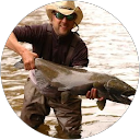 Home Vadim of Perfectum Plumbing holding a large fish, demonstrating dedication and quality service.